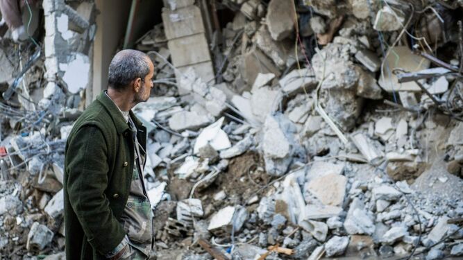 Un hombre pasea junto a los escombros causados por el terremoto