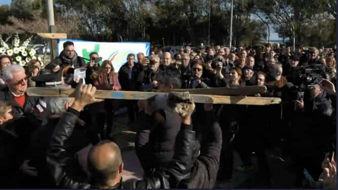 Los fieles trasladan la cruz elaborada con los restos de la embarcación naufragada en Cutro, Italia