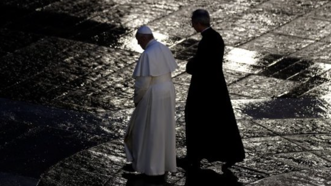 El Papa, con el ceremoniero, cruza la soliataria plaza de San Pedro
