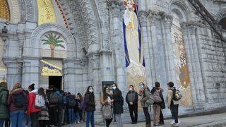 Unos jóvenes ante la fachada de la basílica, adornada con los mosaicos de Rupnik