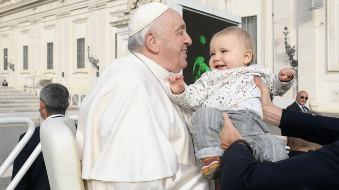 Francisco saluda a un bebé en la plaza de San Pedro