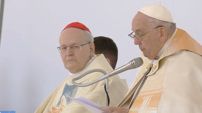 Peter Erdö escucha la homilía del Papa en Budapest
