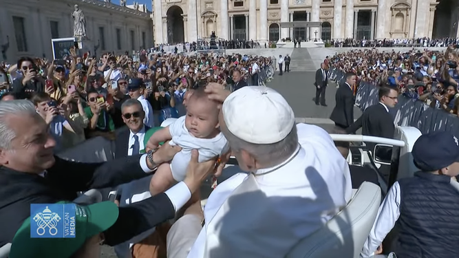 Francisco bendice a un bebé durante su recorrido por las de San Pedro
