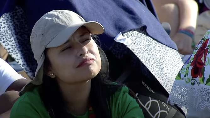 Una joven escucha las palabra del Papa en la homilía