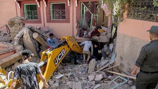 Una excavadora retira el escombro tras el terremoto