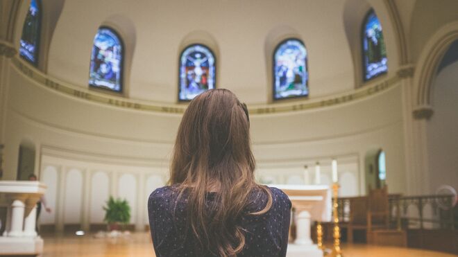 Mujer rezando en una iglesia