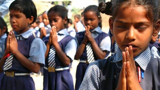 Niños y niñas rezando en India