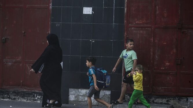Una madre palestina y sus hijos buscan refugio tras un ataque aéreo de Israel en Gaza