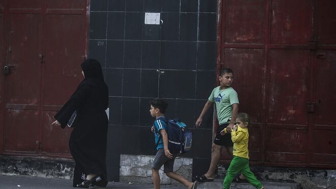 Una madre palestina y sus hijos buscan refugio tras un ataque aéreo de Isreal en Gaza