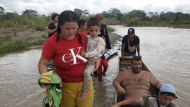 Una mujer migrante, con un menor, en la selva del Darién