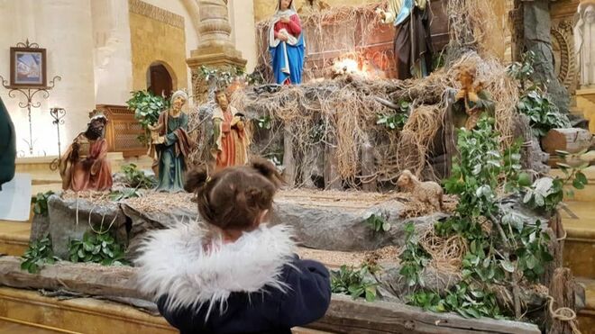 Una niña contempla un belén en una parroquia de Siria