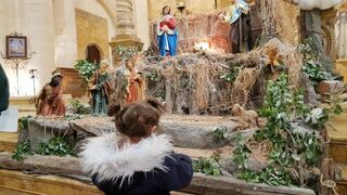 Una niña contempla un belén en una parroquia de Siria