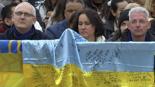 Fieles con una bandera de Ucrania