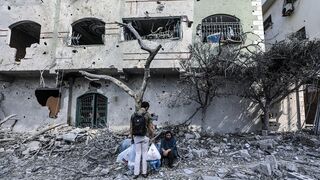 Palestinos en medio de los escombros tras un bombardeo israelí en Gaza