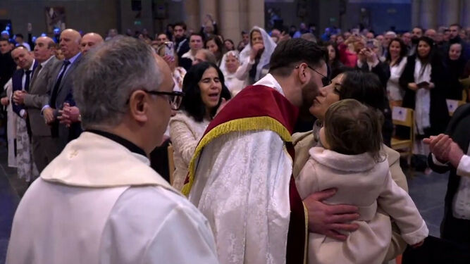 Un sacerdote, tras ser ordenado, besa a su mujer y a uno de sus hijos
