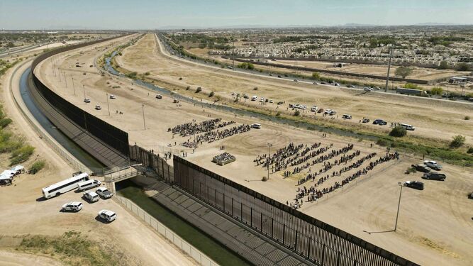 Cientos de migrantes esperan junto al muro fronterizo en El Paso, Texas (EE.UU)