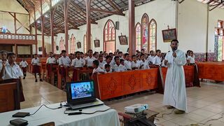 Un seminarista imparte una clase de catequesis para los niños de primaria en la isla de Flores (Indonesia)