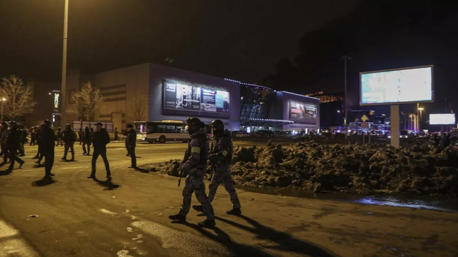 Agentes rusos vigilan el área cerca de la sala de conciertos en llamas Crocus City Hall después de un tiroteo en Krasnogorsk, en las afueras de Moscú