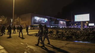 Agentes rusos vigilan el área cerca de la sala de conciertos en llamas Crocus City Hall después de un tiroteo en Krasnogorsk, en las afueras de Moscú