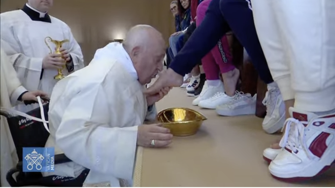 Francisco besa los pies de una de las reclusas