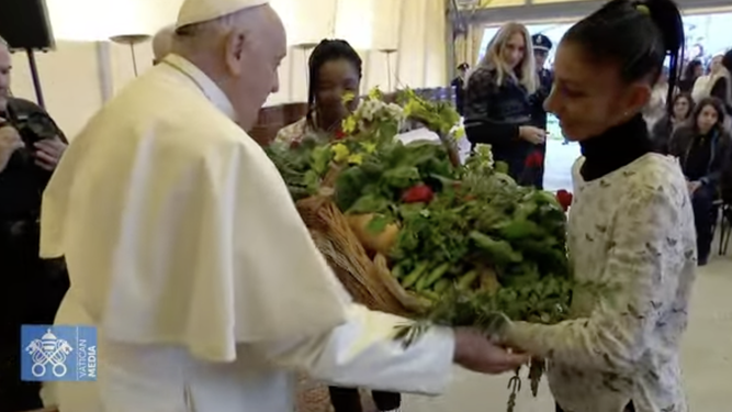 Unas jóvenes presas entregan un regalo elaborado por ellas en la cárcel