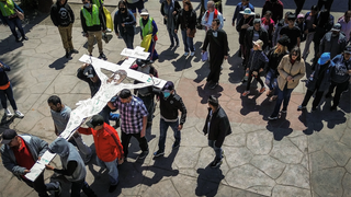 Los migrantes pintaron dibujos en la cruz, cada uno representando su viaje