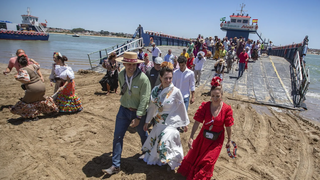 Romeros cruzan el Guadalquivir en barcazas