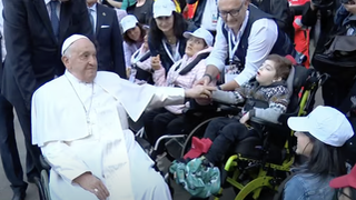 Francisco saluda, desde su silla de ruedas, a un menor discapacitado