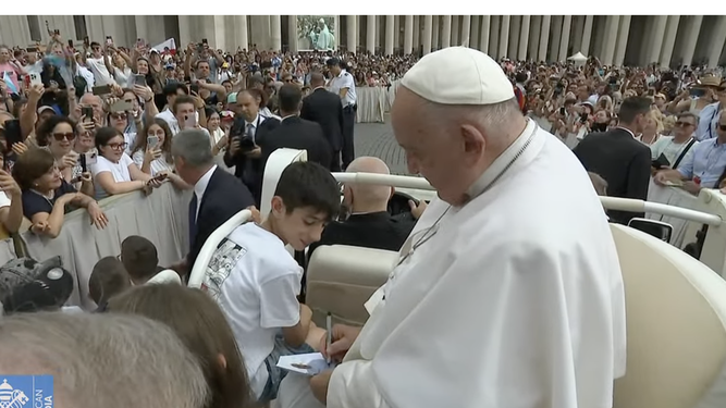 Francisco firma un autógrafo en el papamóvil