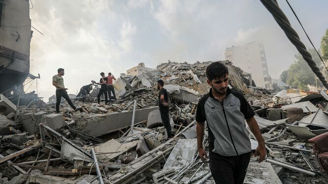 Palestinos caminan sobre los escombros de una bombardeada Gaza