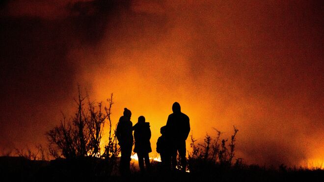 Una familia observa un incendio