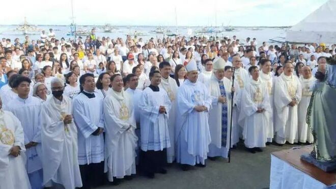 El arzobispo Villegas y otros rezan el rosario durante la procesión fluvial