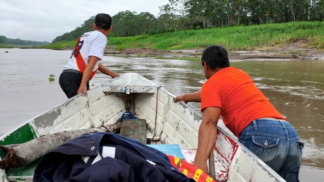 Empujando el bote varado por el bajo nivel del río