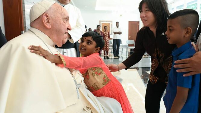 Una niña se abraza al Papa Francisco a su llegada a la Nunciatura de Yakarta