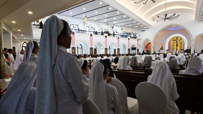 Una religiosa, en pie, escucha al Papa en Timor
