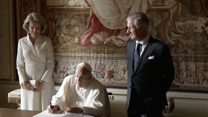 Francisco firma en el libro de honor ante los Reyes de Bélgica