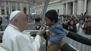 Francisco enseña una medalla a un niño