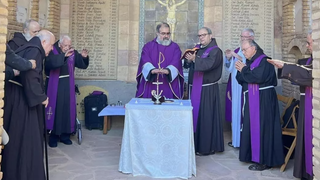 El hermano Fernando sujeta el Evangelio mientras el hermano ángel consagra el pan y el vino, en una imagen de archivo