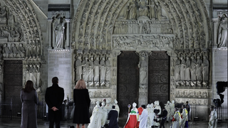 El arzobispo de París se dirige a la puerta de la catedral ante la mirada de Macron