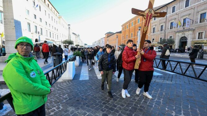 Un voluntario con un grupo de jóvenes peregrinos en el Vaticano