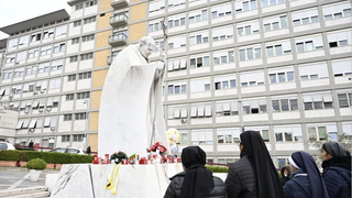 Unas monjas rezan por elFrancisco ante la estatua de Juan Pablo II a la entrada del Gemelli