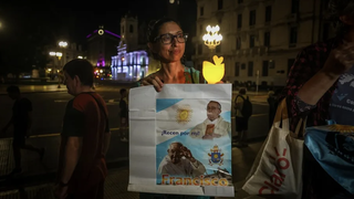 Una mujer sostiene un cartel del Papa frente a la catedral de Buenos Aires