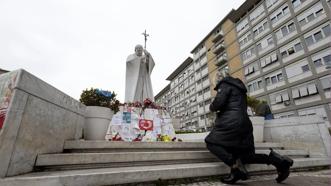 Una mujer reza ante el Gemelli por la salud del papa Francisco