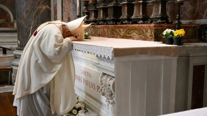 Dziwisz reza ante la tumba de san Juan Pablo II