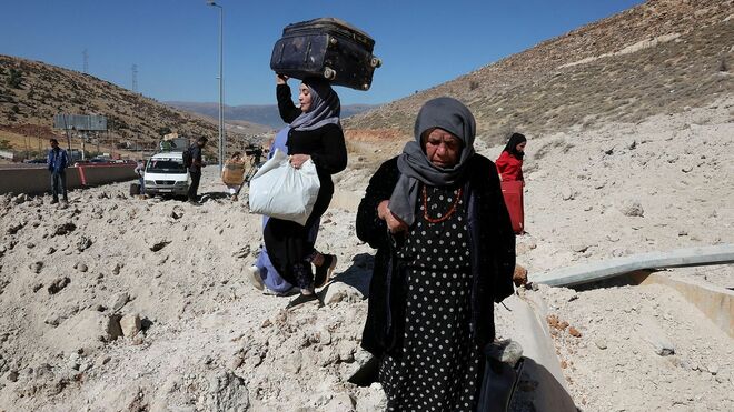 Refugiados cruzan el paso fronterizo entre Siria y el Líbano