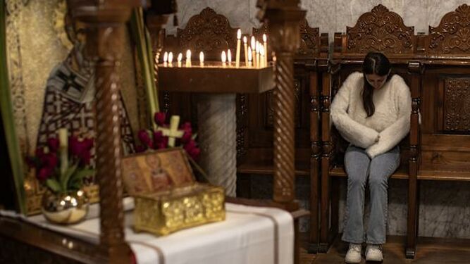 Una joven reza el Domingo de Ramos en una parroquia de Gaza