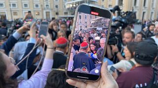 Periodistas con un cardenal en la plaza de San Pedro