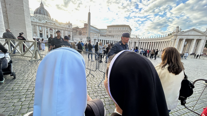 Dos religiosas miran hacia la chimenea sobre la Sixtina