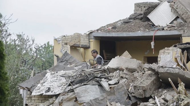 Un hombre despeja de escombros su casa, cerca de Kiev, tras bombardeos rusos