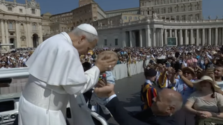 El Papa bendice a un niño en la plaza de San Pedro